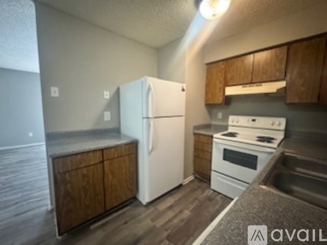 A kitchen with a white refrigerator and wooden cabinets.