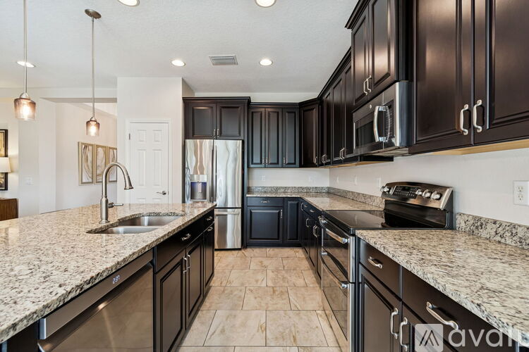 A kitchen with black cabinets and granite countertops.