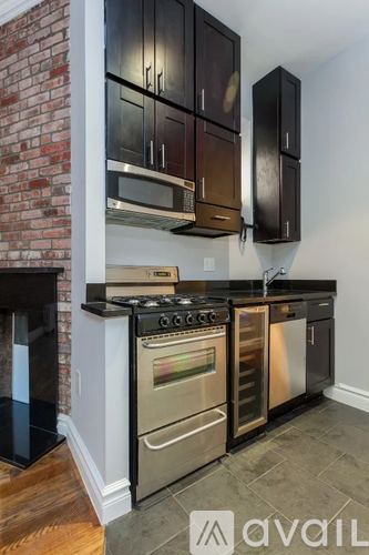 A kitchen with a brick wall and stainless steel appliances.