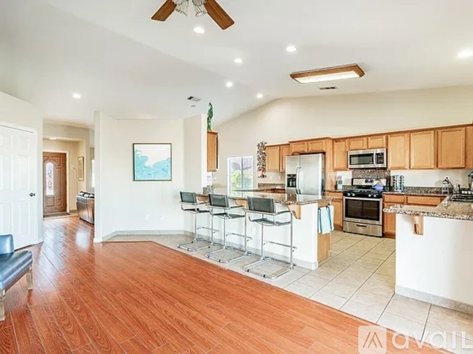 A kitchen with a dining table and chairs.