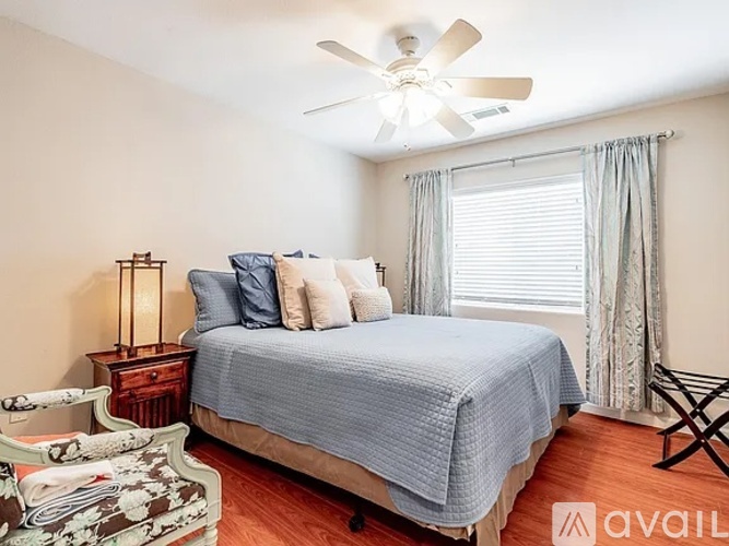 A bedroom with a bed, nightstand, and window.