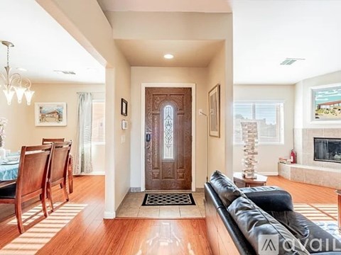 A living room with a black couch and a wooden door.