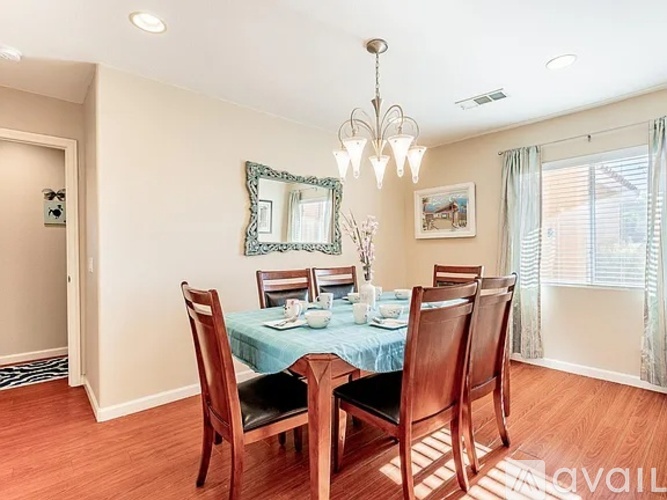 A dining room with a table set for four.