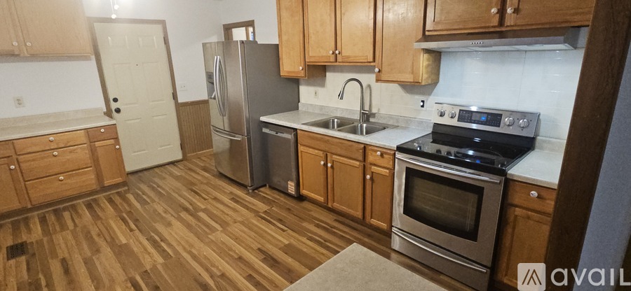 A kitchen with wooden floors and stainless steel appliances.
