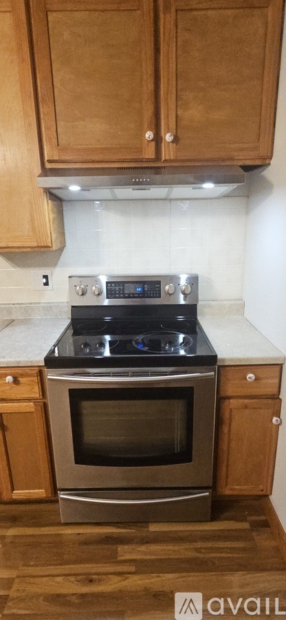 A kitchen with wooden cabinets and a stainless steel oven.