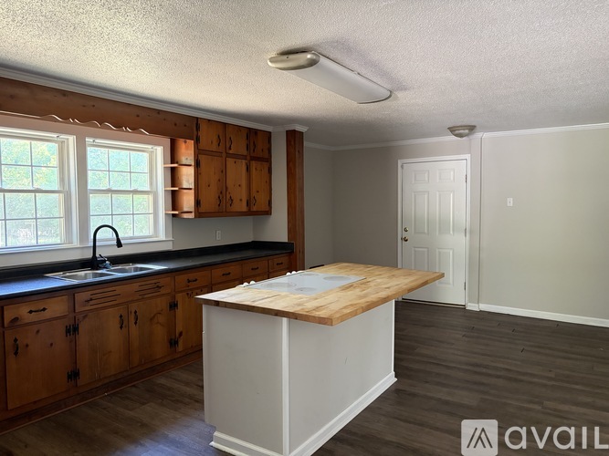 A kitchen with wooden cabinets and a white island.