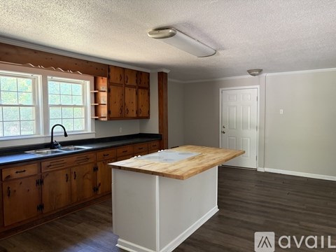 A kitchen with wooden cabinets and a white island.