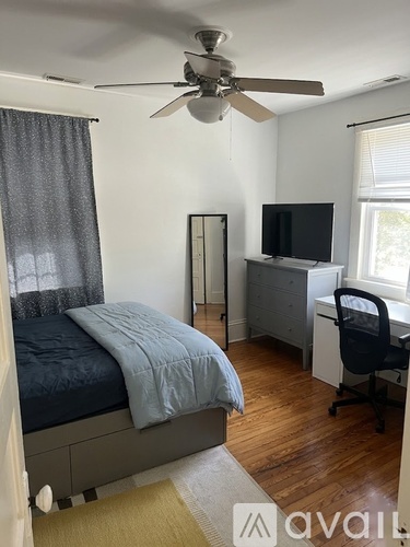 A bedroom with a bed, desk, and chair.