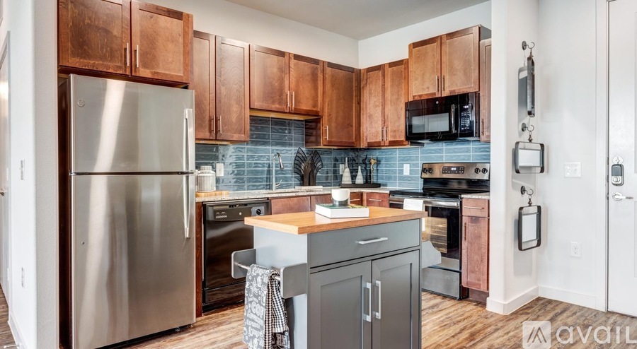A kitchen with wooden cabinets and a stainless steel refrigerator.