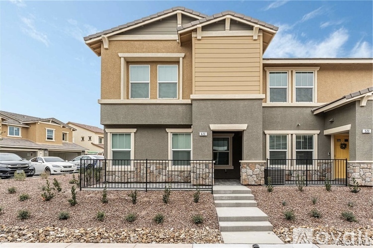 A modern two-story house with a front yard and a driveway.