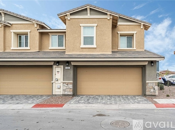 A two-story house with a garage and a car parked in it.