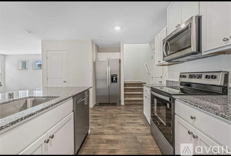 A kitchen with white cabinets and stainless steel appliances.