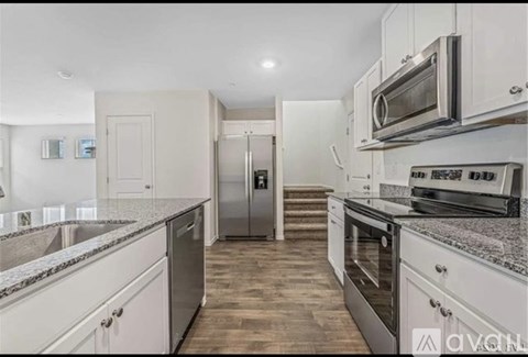 A kitchen with white cabinets and stainless steel appliances.
