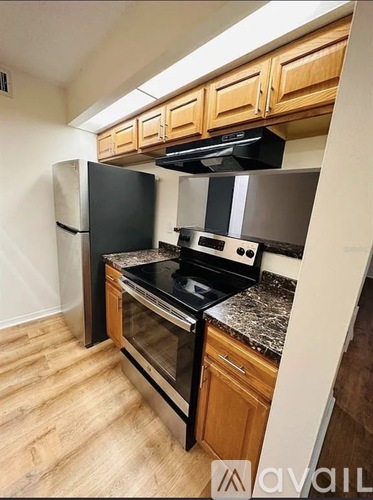 A kitchen with wooden cabinets and black appliances.
