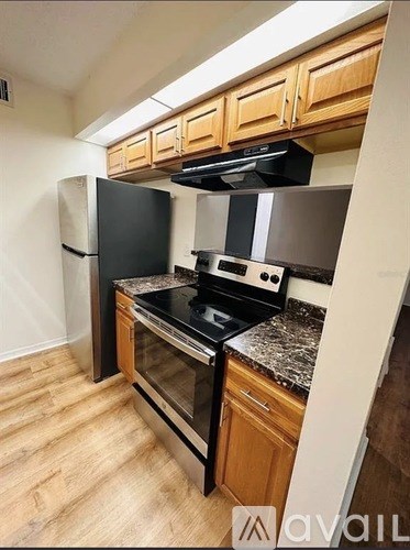 A kitchen with wooden cabinets and black appliances.