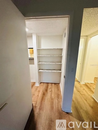 A white closet with shelves and a door is shown.