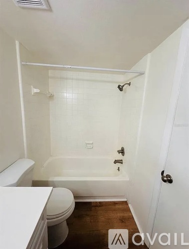 A white bathroom with a toilet, tub, and sink.