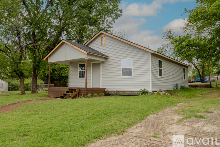 A house with a grey siding and a brown porch.