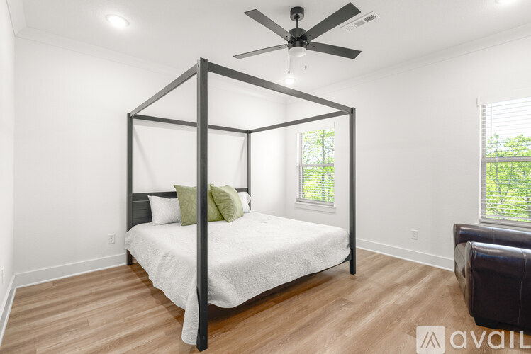 A bedroom with a four-poster bed and a ceiling fan.