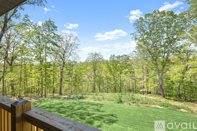 A view from a deck overlooking a grassy area with trees.