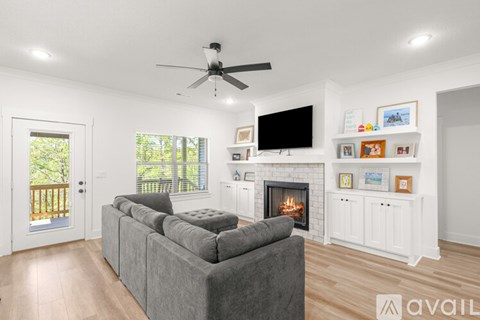 A living room with a grey couch and a fireplace.