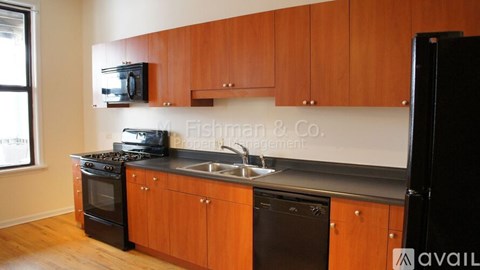 A kitchen with wooden cabinets and black appliances.