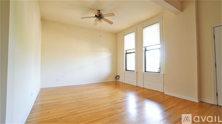 A room with a ceiling fan and wooden flooring.