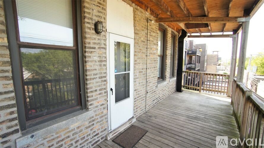 A balcony with a door and windows on a brick building.