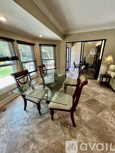 A living room with a glass table and chairs.