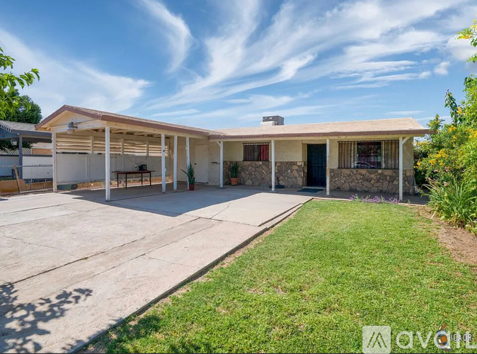 A house with a covered patio and a stone wall.