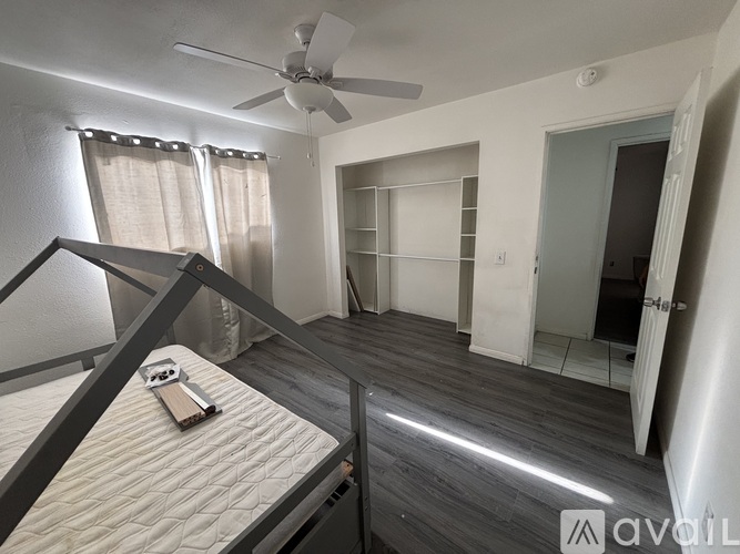 A bedroom with a bed, a ceiling fan, and a wardrobe.