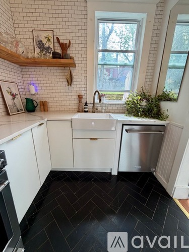 A kitchen with white cabinets and a black floor.