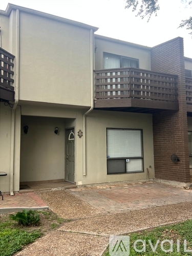 A two-story building with a balcony and a door.
