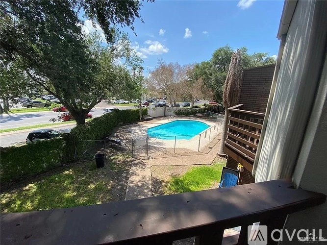 A backyard with a pool and a tree.