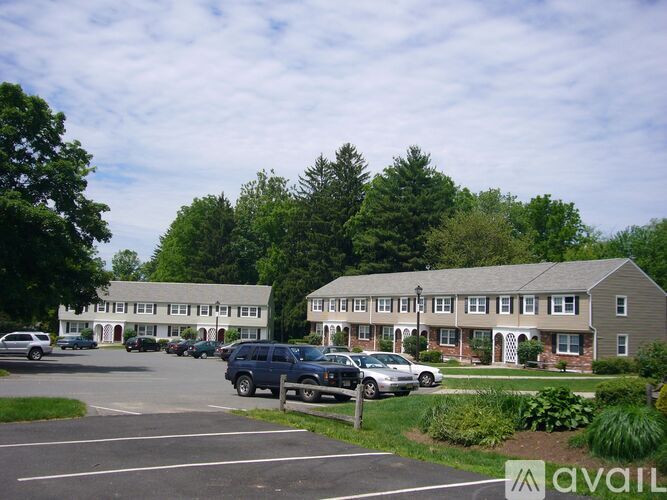 A parking lot with cars and a building in the background.