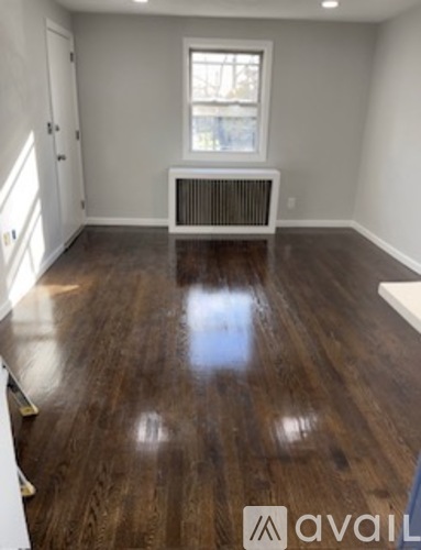 A room with a wooden floor and a window.