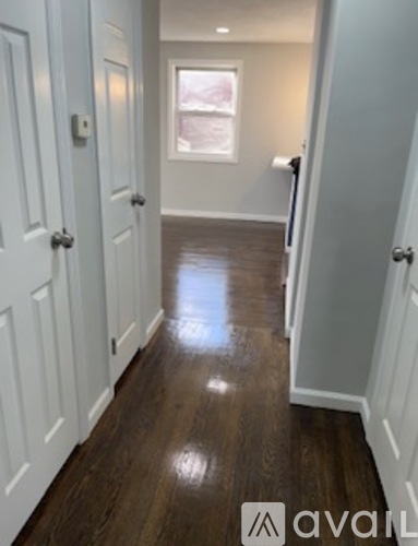 A hallway with wood floors and white doors.