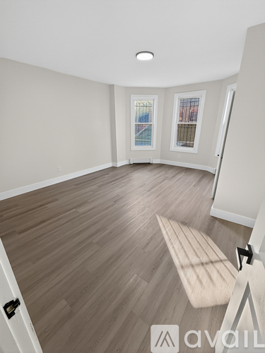 A room with wooden flooring and a bench.