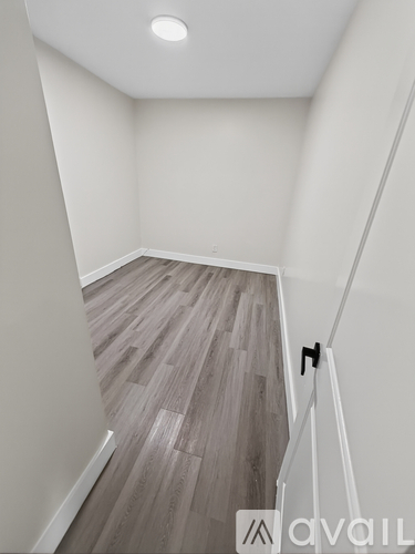 A room with a wooden floor and white walls.