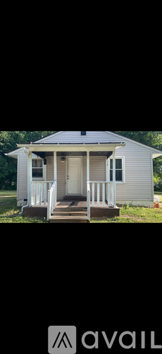 A small white house with a porch and a door.