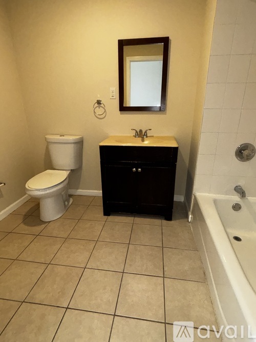 A bathroom with a toilet, sink, and bathtub.