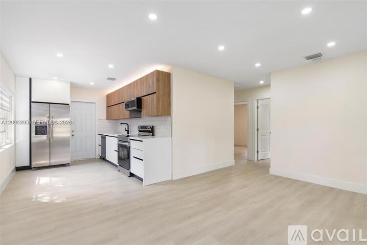 A modern kitchen with white cabinets and a wooden accent on the island.