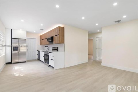 A modern kitchen with white cabinets and a wooden accent on the island.