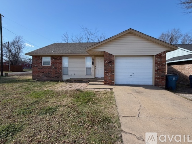 A house with a garage and a driveway in front.