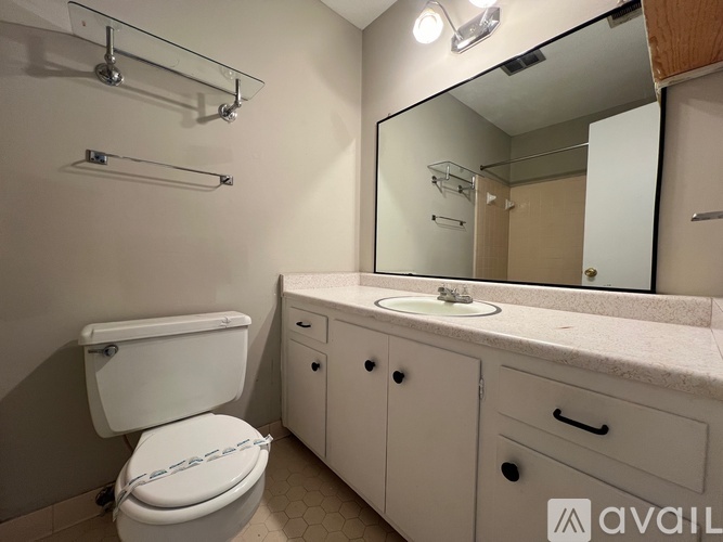 A white toilet with a white tank and a white sink with a white counter top.