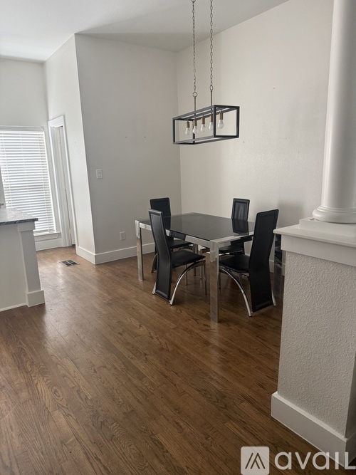 A dining room with a table and chairs.