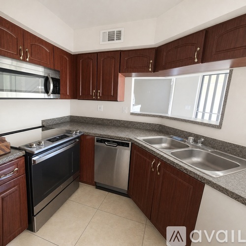 A kitchen with dark wood cabinets and stainless steel appliances.