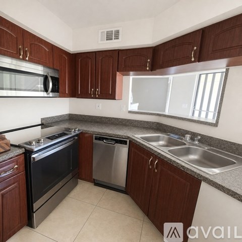 A kitchen with dark wood cabinets and stainless steel appliances.