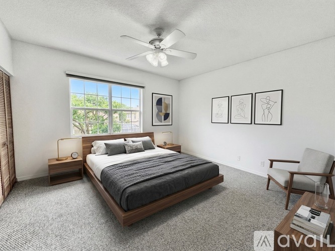 A bedroom with a large bed, a ceiling fan, and a chair.