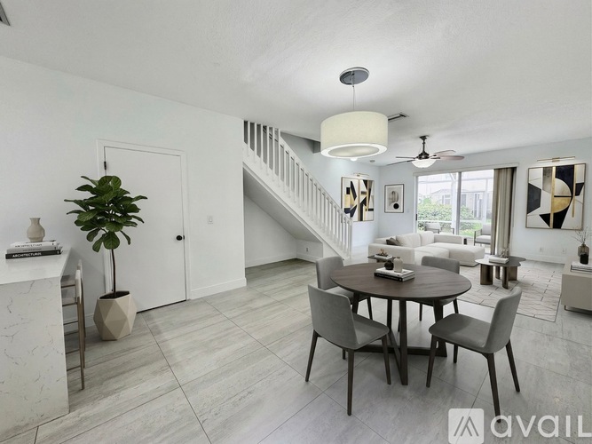 A living room with a dining table and chairs.